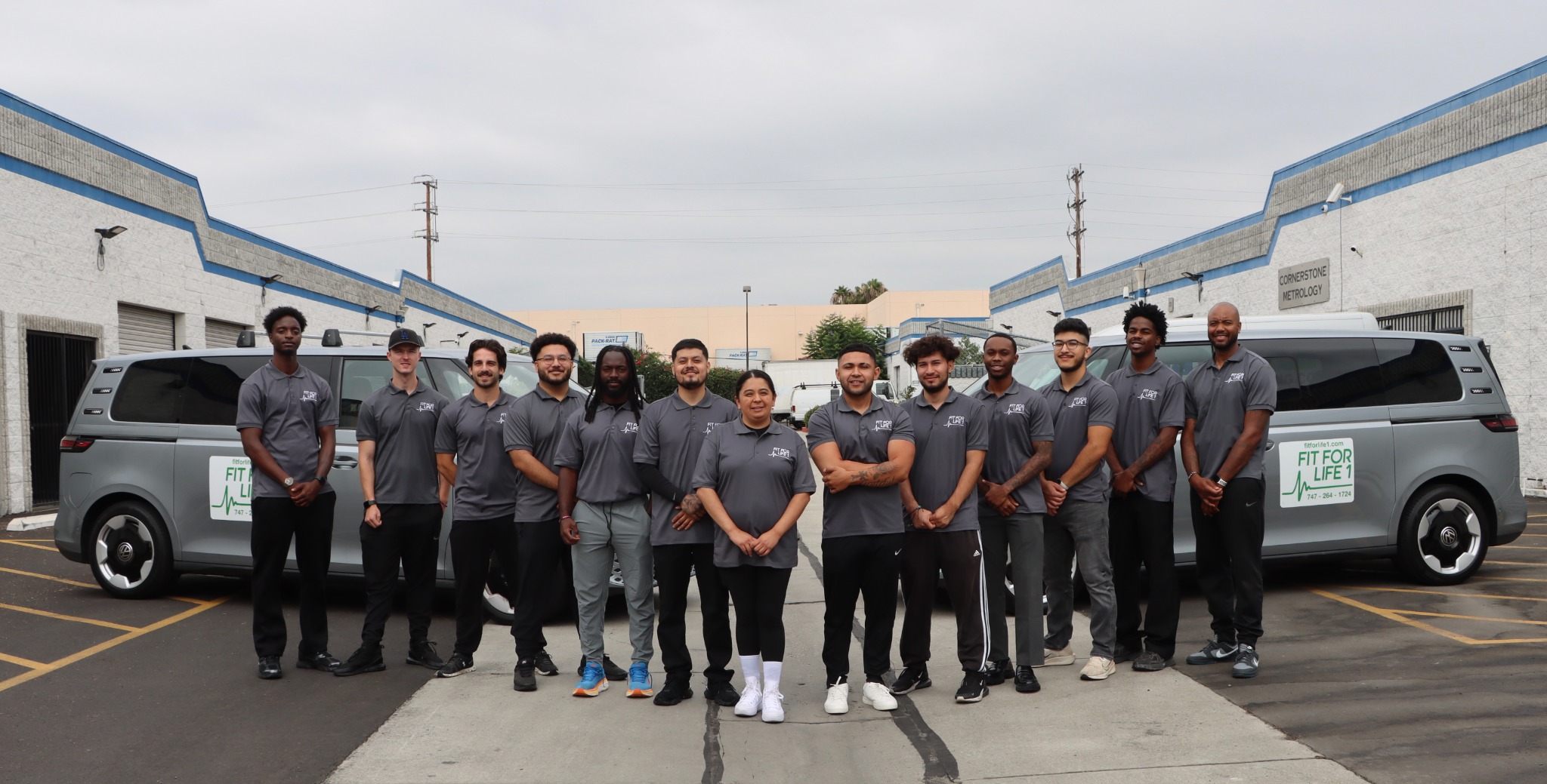 Fit For Life team standing in front of transportation vans